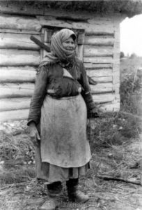 Russische Frau vor ihrer Hütte